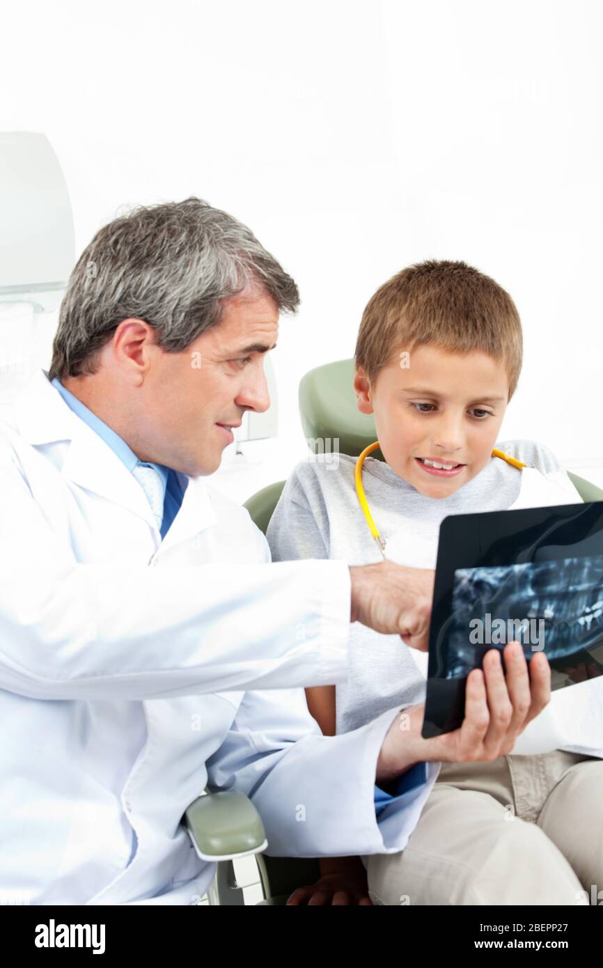 Il dentista mostra una radiografia a un bambino ansioso Foto Stock