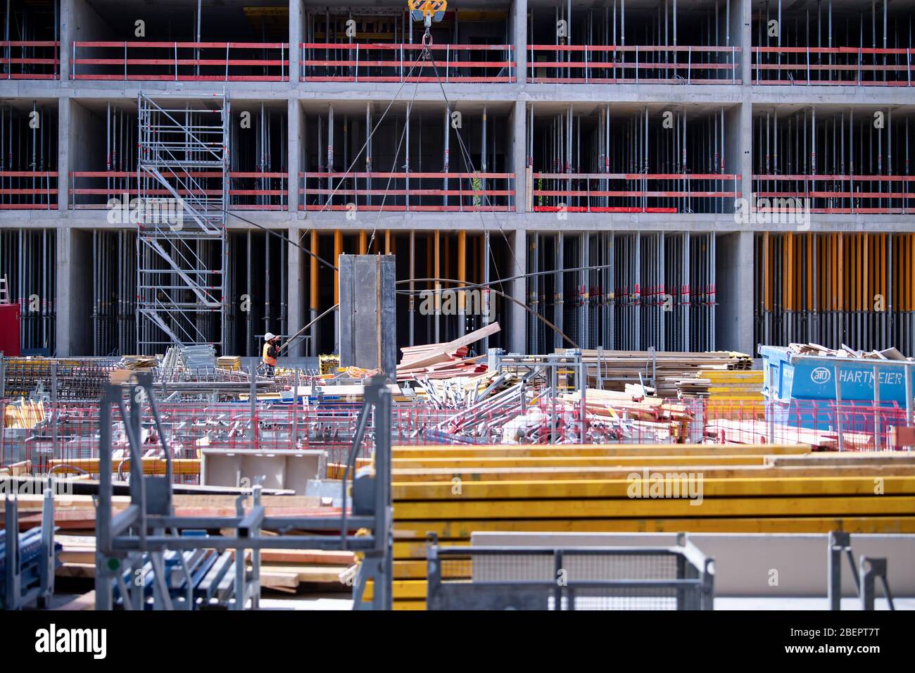 Monaco, Germania. 15 aprile 2020. Un operaio di costruzione cammina attraverso il luogo di costruzione del nuovo centro di giustizia penale. Dopo il suo completamento, il nuovo edificio di circa 39,000 metri quadri su Leonrodplatz sostituirà l'edificio vecchio su Nymphenburger Strasse. Tra gli altri, parti dei due tribunali regionali, il tribunale regionale superiore e gli uffici pubblici dei procuratori di Monaco si sposteranno nell'edificio stimato a 300 milioni di euro. Credit: Sven Hoppe/dpa/Alamy Live News Foto Stock