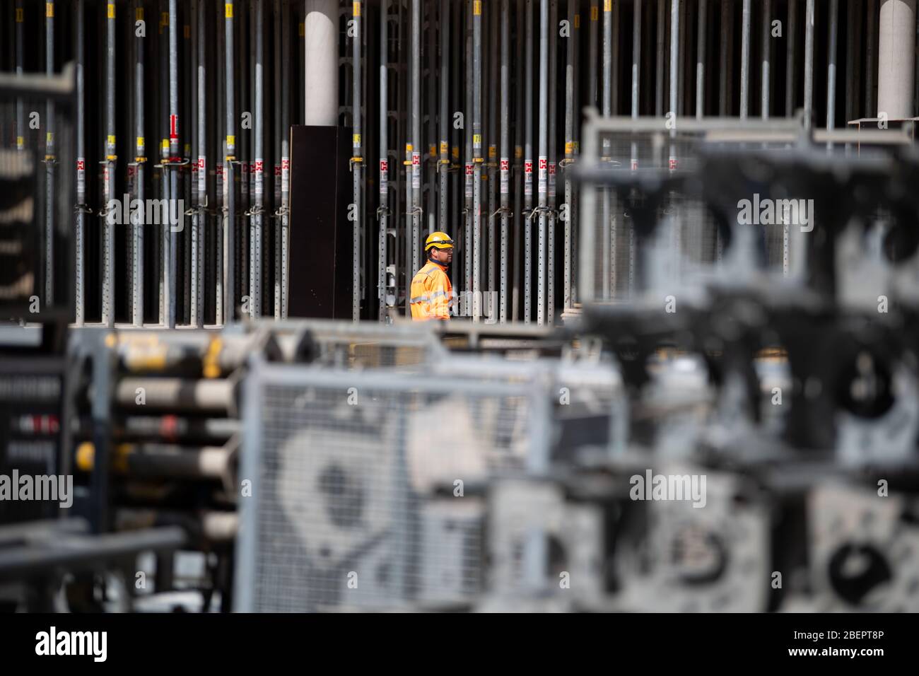 Monaco, Germania. 15 aprile 2020. Un operaio di costruzione cammina attraverso il cantiere del nuovo centro di giustizia penale. Dopo il suo completamento, il nuovo edificio di circa 39,000 metri quadri su Leonrodplatz sostituirà l'edificio vecchio su Nymphenburger Strasse. Tra gli altri, parti dei due tribunali regionali, il tribunale regionale superiore e gli uffici pubblici dei procuratori di Monaco si sposteranno nell'edificio stimato a 300 milioni di euro. Credit: Sven Hoppe/dpa/Alamy Live News Foto Stock