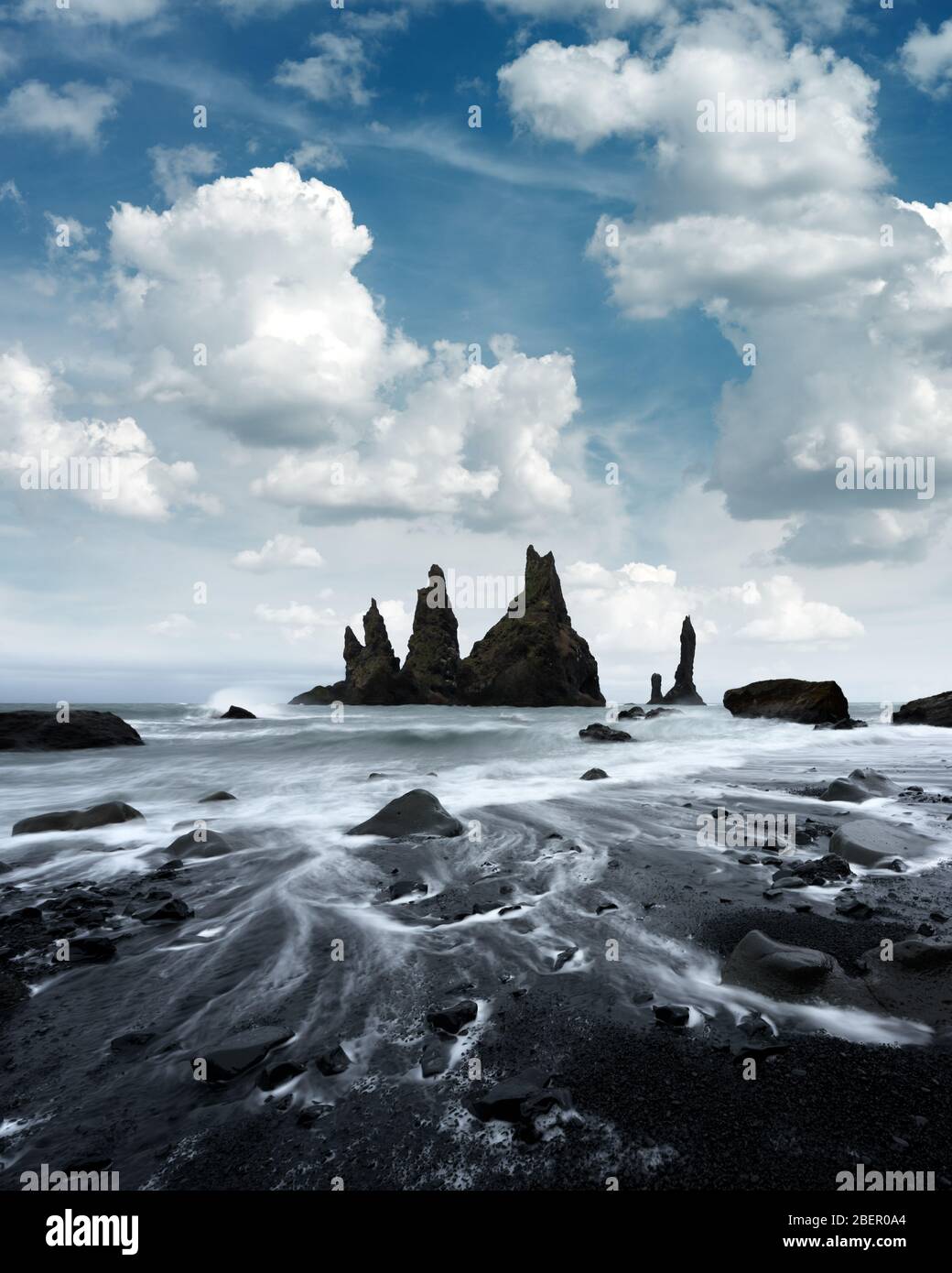 Paesaggio mozzafiato con formazioni rocciose basaltiche Troll Toes sulla spiaggia Nera, onde oceaniche e paesaggio nuvoloso. Reynisdragar, Vik, Islanda Foto Stock