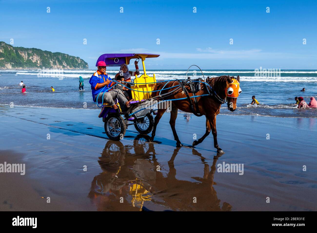 Persone indonesiane che si godono UN giro in carrozza a cavallo sulla Parangtritis Beach, Yogyakarta, Indonesia. Foto Stock