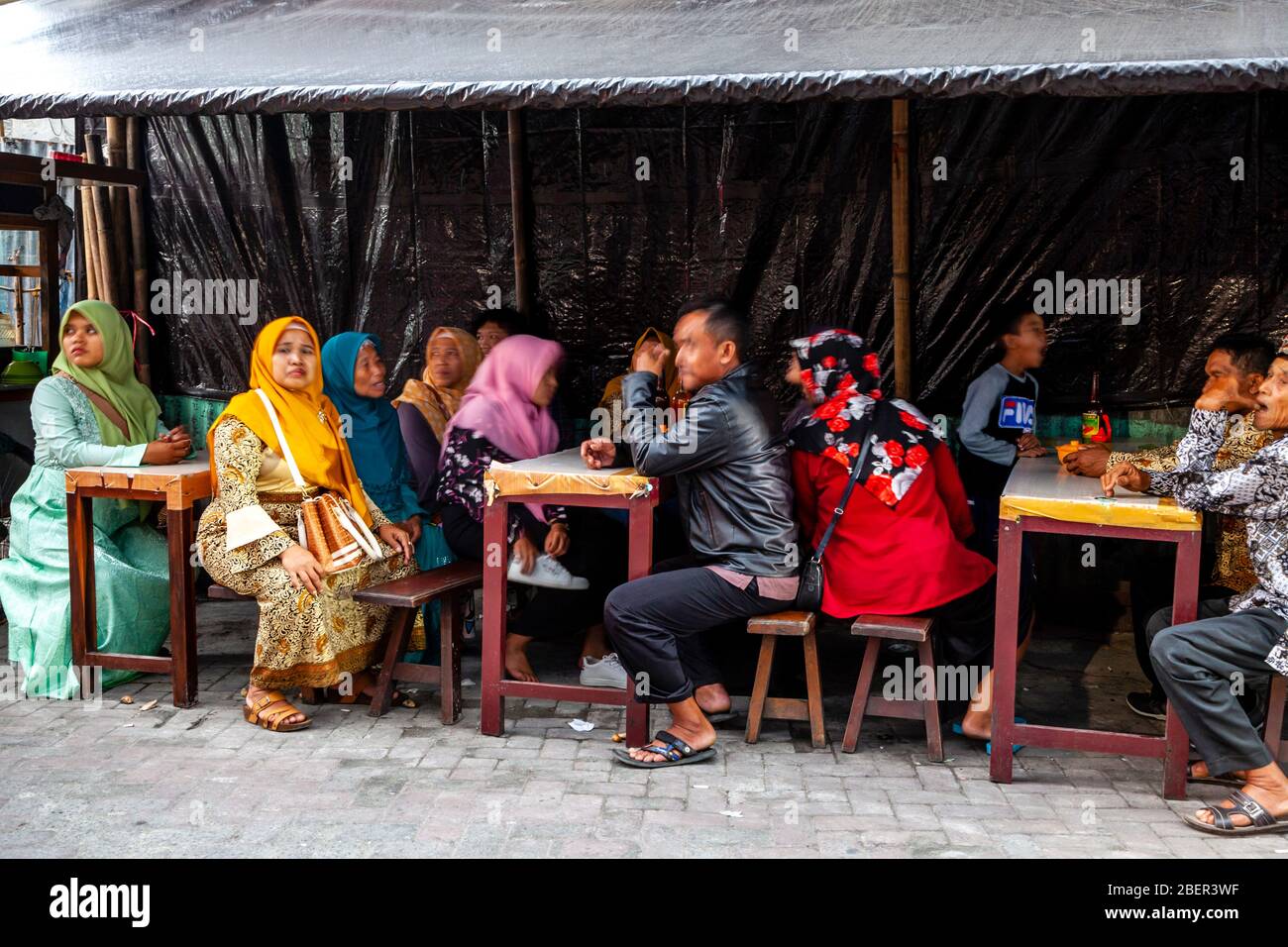Un gruppo di persone indonesiane che siedono presso UN caffè all'aperto, Malioboro Street, Yogyakarta, Indonesia. Foto Stock