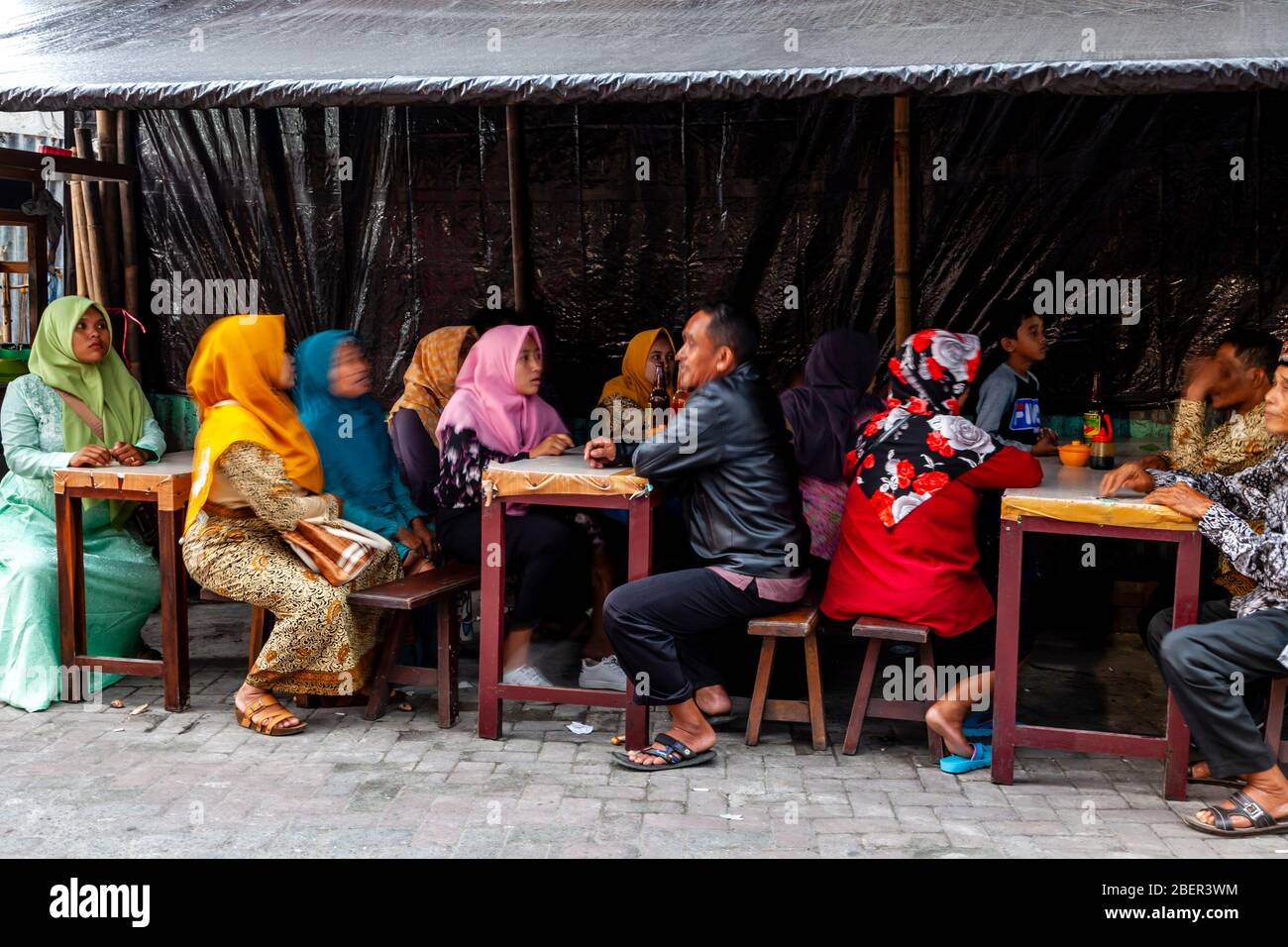 Un gruppo di persone indonesiane che siedono presso UN caffè all'aperto, Malioboro Street, Yogyakarta, Indonesia. Foto Stock