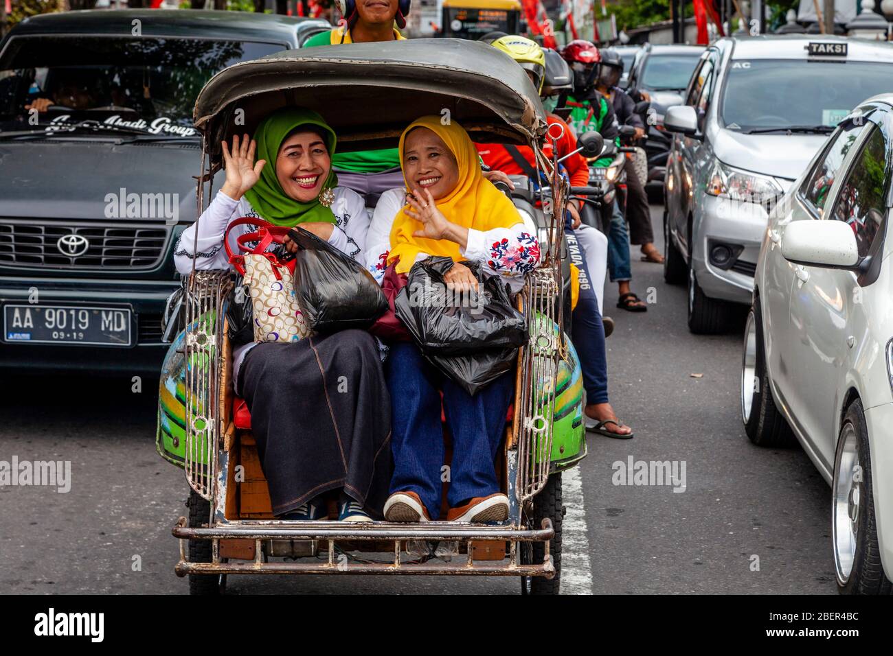 Due donne indonesiane sorridenti che viaggiano in taxi, Yogyakarta, Indonesia. Foto Stock