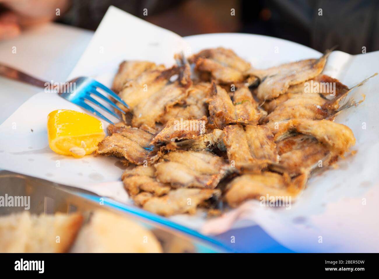 Primo piano di acciuga fritta e servita con limone. Foto Stock