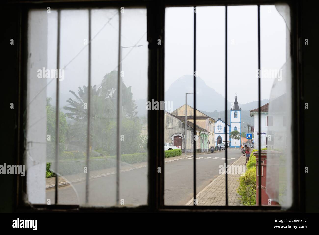 17 febbraio 2020, São Tomé e Príncipe, Santo Antonio: Vista attraverso una finestra a graticcio della chiesa Nossa Senhora da Conceicao di fronte al monte Pico do Papagaio Foto: Sebastian Kahnert/dpa-Zentralbild/dpa Foto Stock