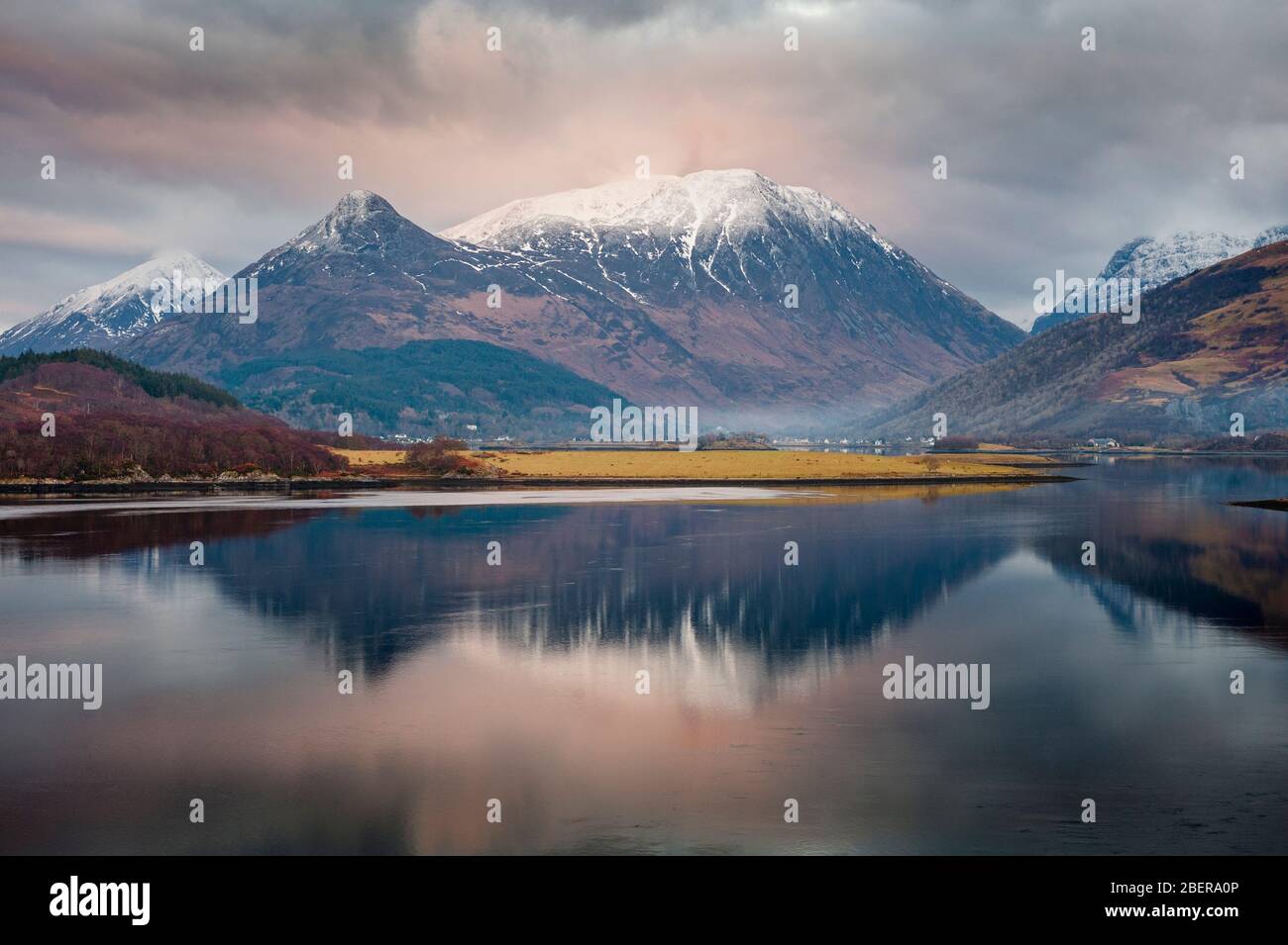Paesaggio invernale delle Highlands scozzesi - Loch Leven e riflesso delle montagne innevate, tra cui il Pap of Glencoe e Aonach Eagach Foto Stock