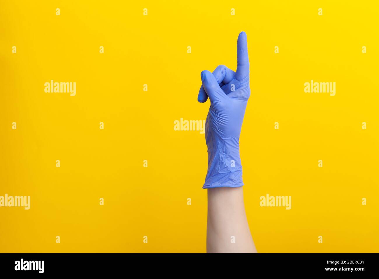 Medico mano in lilla medico guanto per uso singolo è dito rivolto verso l'alto Foto Stock