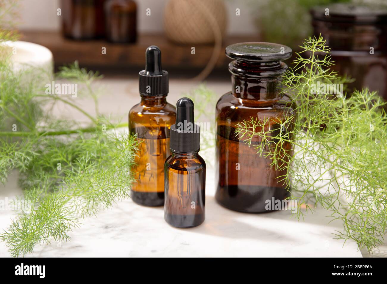 Olio essenziale di finocchio su bottiglie ambrate. Olio di erbe per la cura della pelle, aromaterapia e medicina naturale Foto Stock