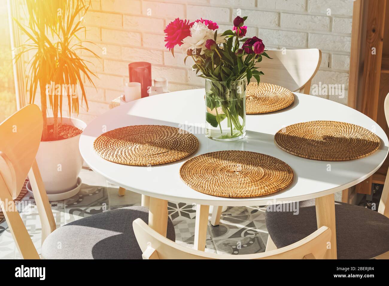 Sala da pranzo piena di luce del sole con peonie nel vaso Foto Stock