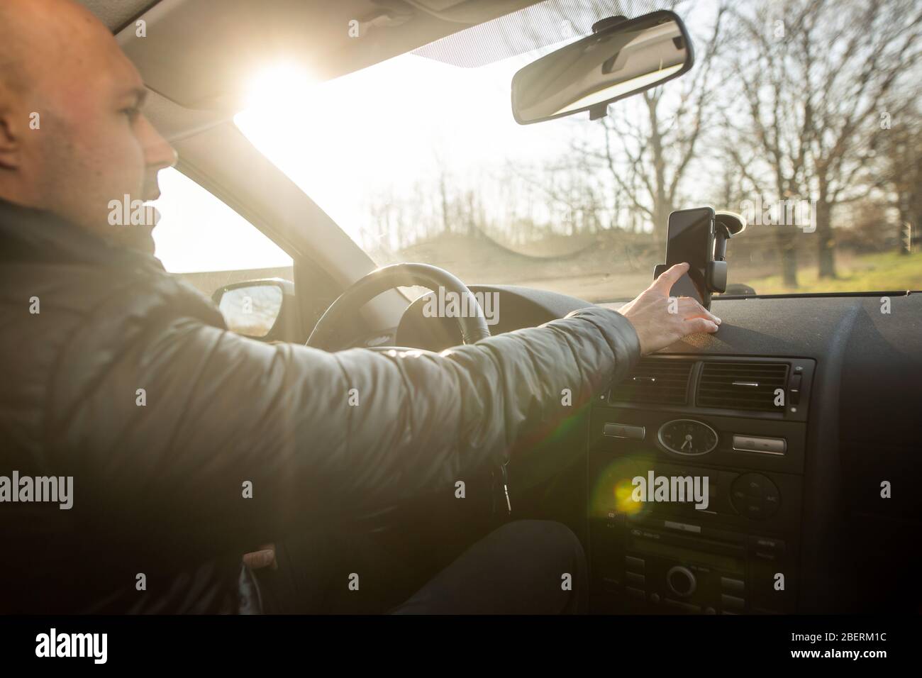 Uomo che imposta il GPS sul mobile prima della sua guida, assisstant durante la guida dell'automobile, concetto di trasporto Foto Stock