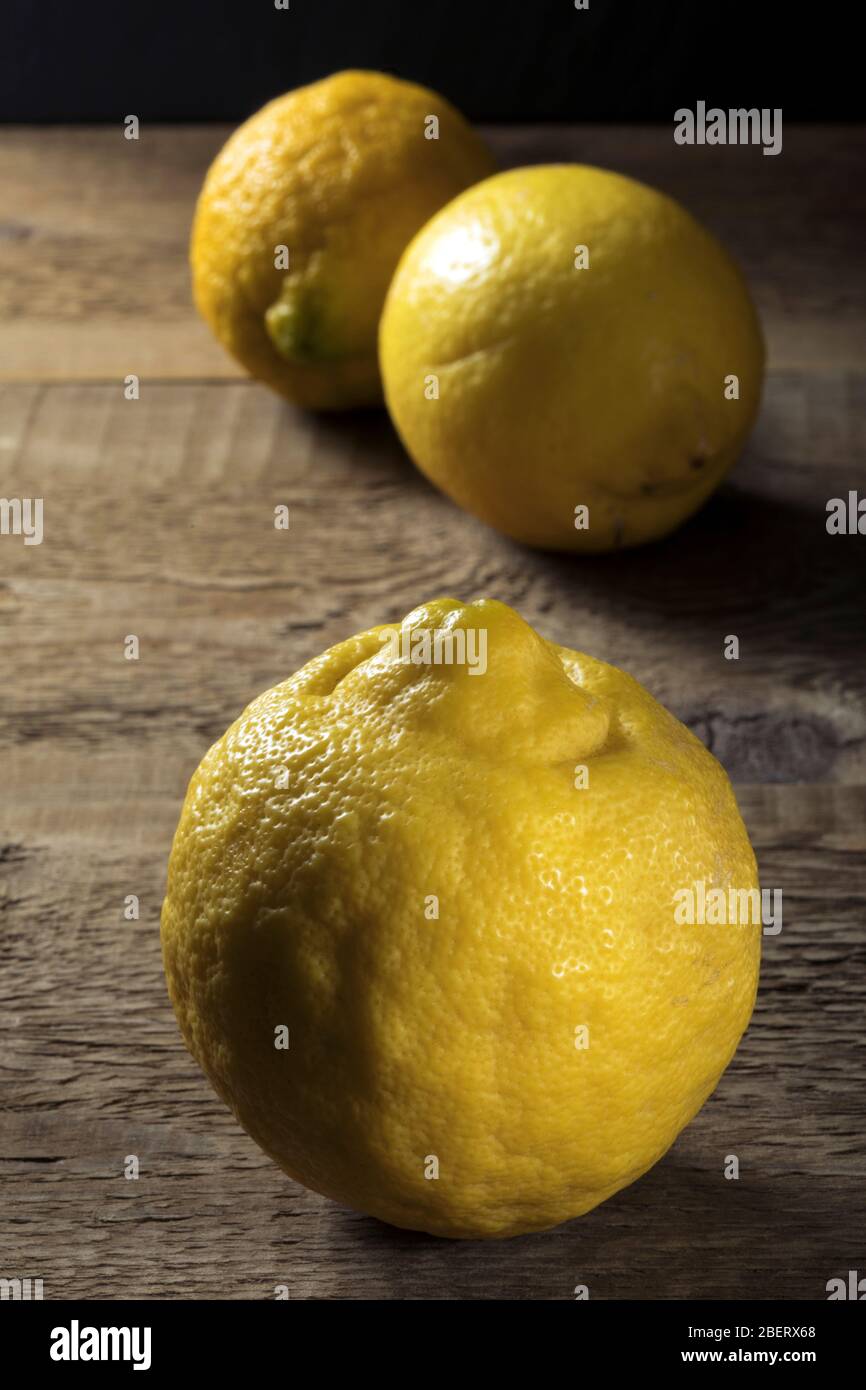 Limoni biologici freschi su un tavolo di legno. Foto Stock