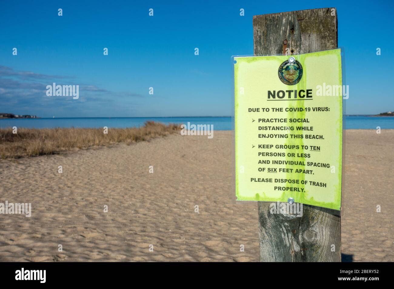 Covid-19 Virus Notice sulla spiaggia per la distanza sociale di sei piedi di distanza e gruppi dieci persone o meno Foto Stock