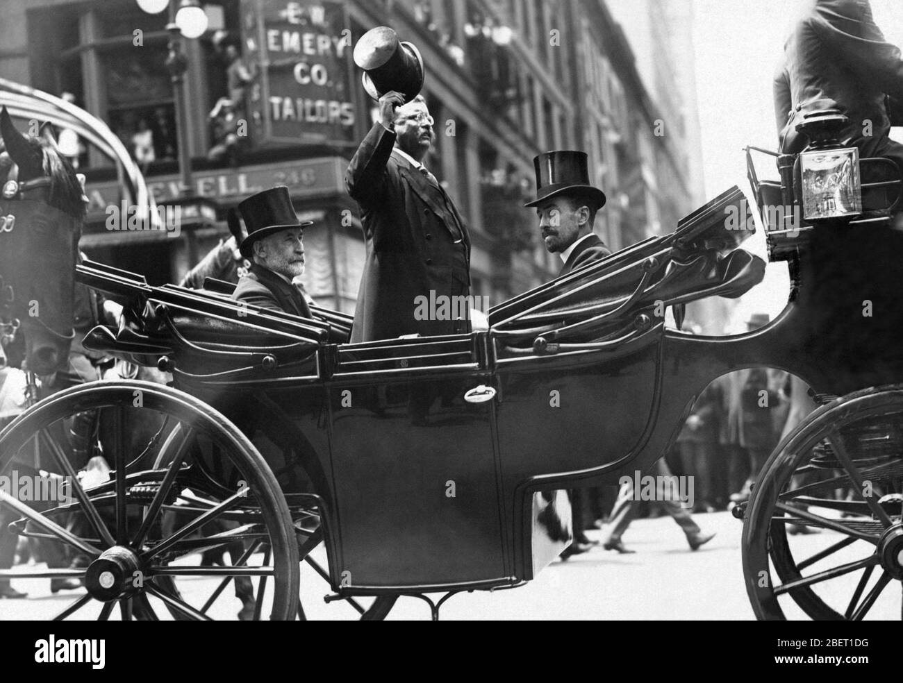 Theodore Roosevelt in una carrozza trainata da cavalli, ribaltando il cappello agli spettatori sulla Fifth Avenue NYC. Foto Stock