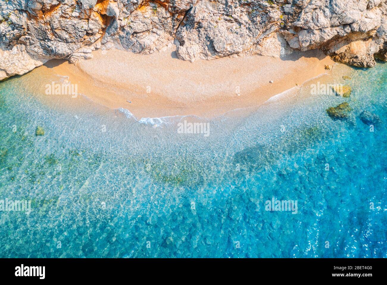 Vista aerea della spiaggia di sabbia con rocce e mare con acqua blu Foto Stock