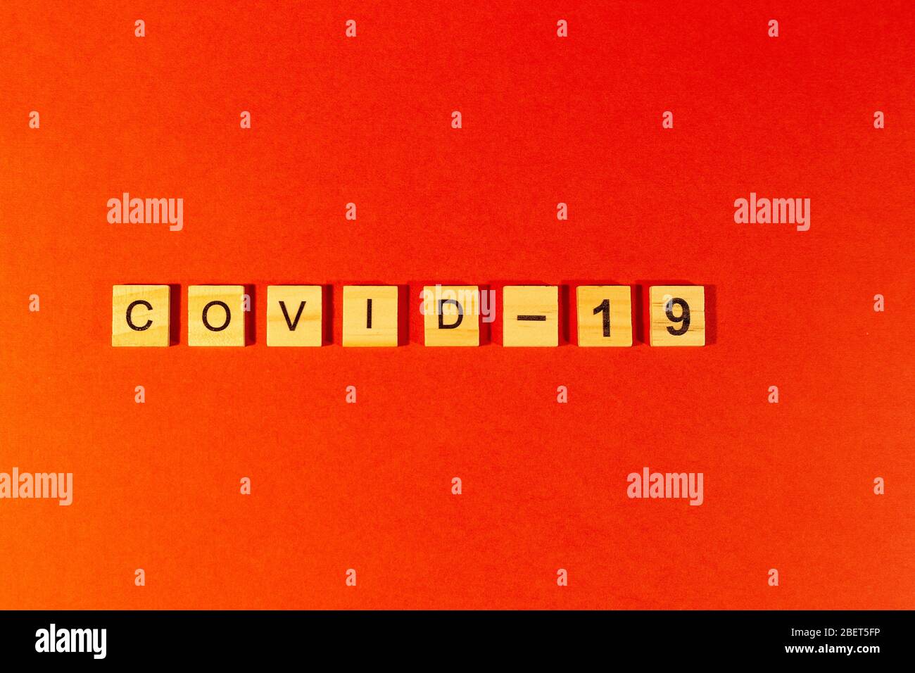 Il concetto di pandemia e di virus è una parola di Coronavirus fatta di lettere di legno. Testo del coronavirus su sfondo rosso. Covid19 Foto Stock