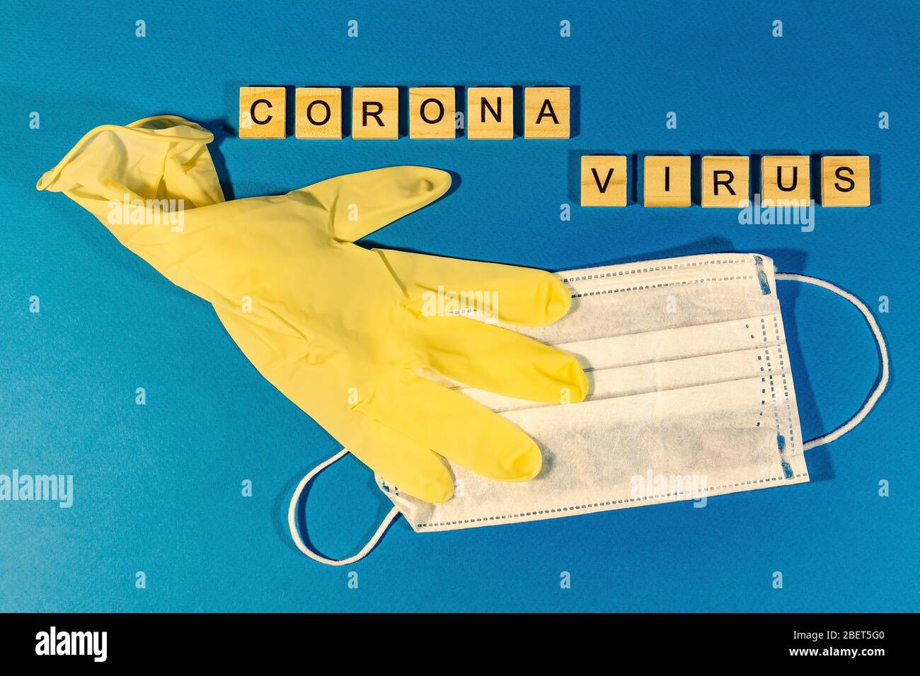 Una maschera medica, guanti medici sulla superficie blu. Concetto di coronavirus, influenza, infezione, epidemia. Vista dall'alto. Orientamento orizzontale. Visualizza da Foto Stock