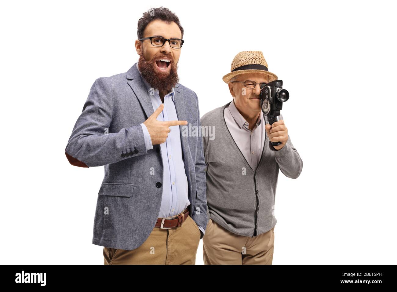 Uomo bearded ridendo e puntando ad un Signore anziano con una macchina fotografica d'epoca isolata su sfondo bianco Foto Stock