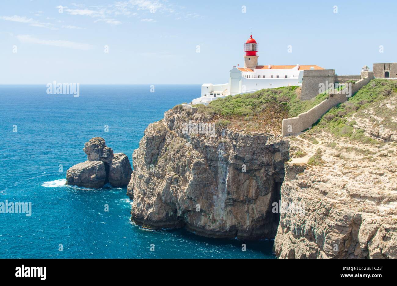 Portogallo, Algarve, vista delle scogliere di Moher e Oceano Atlantico, faro rosso bianco, faro vicino a Sagres in Portogallo, Capo St. Vincent su un d sole Foto Stock