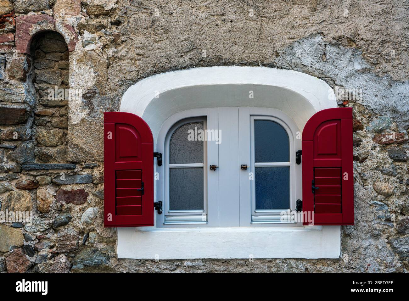 una finestra bianca - rossa in una vecchia casa Foto Stock