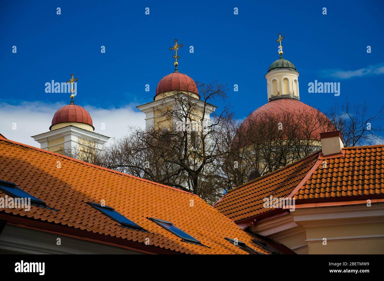 Cupole della chiesa con croci e tetti di tegole rosse e cielo blu sullo sfondo, Vilnius, Lituania Foto Stock