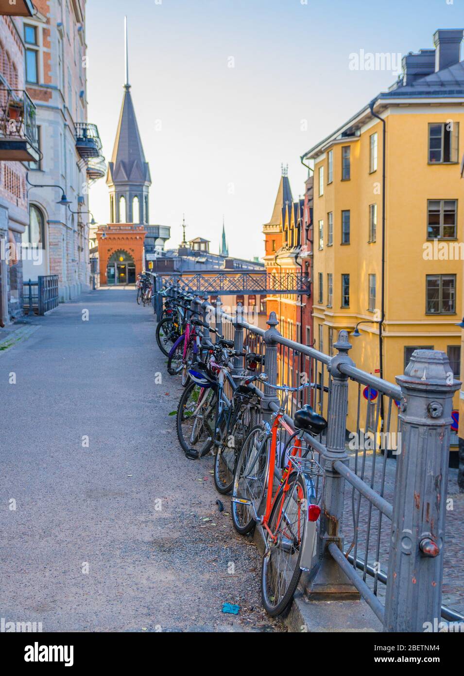 Fila di biciclette parcheggiate, biciclette vicino alla ringhiera nel quartiere dell'isola di Sodermalm con edifici tipici tradizionali, Stoccolma, Svezia Foto Stock