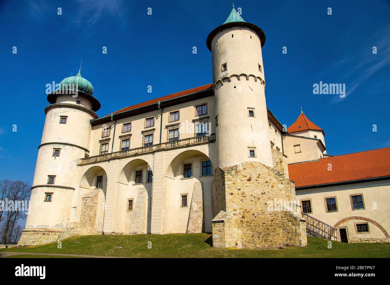 Antico castello medievale a Nowy Wisnicz con torri e prato verde intorno, Polonia Foto Stock