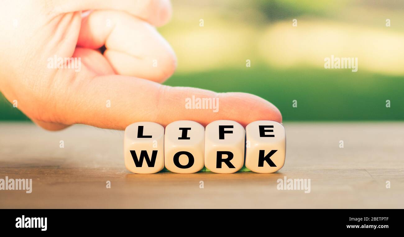 Live vs. Lavoro. La mano gira i dadi e cambia la parola 'lavoro' in 'vita'. Foto Stock