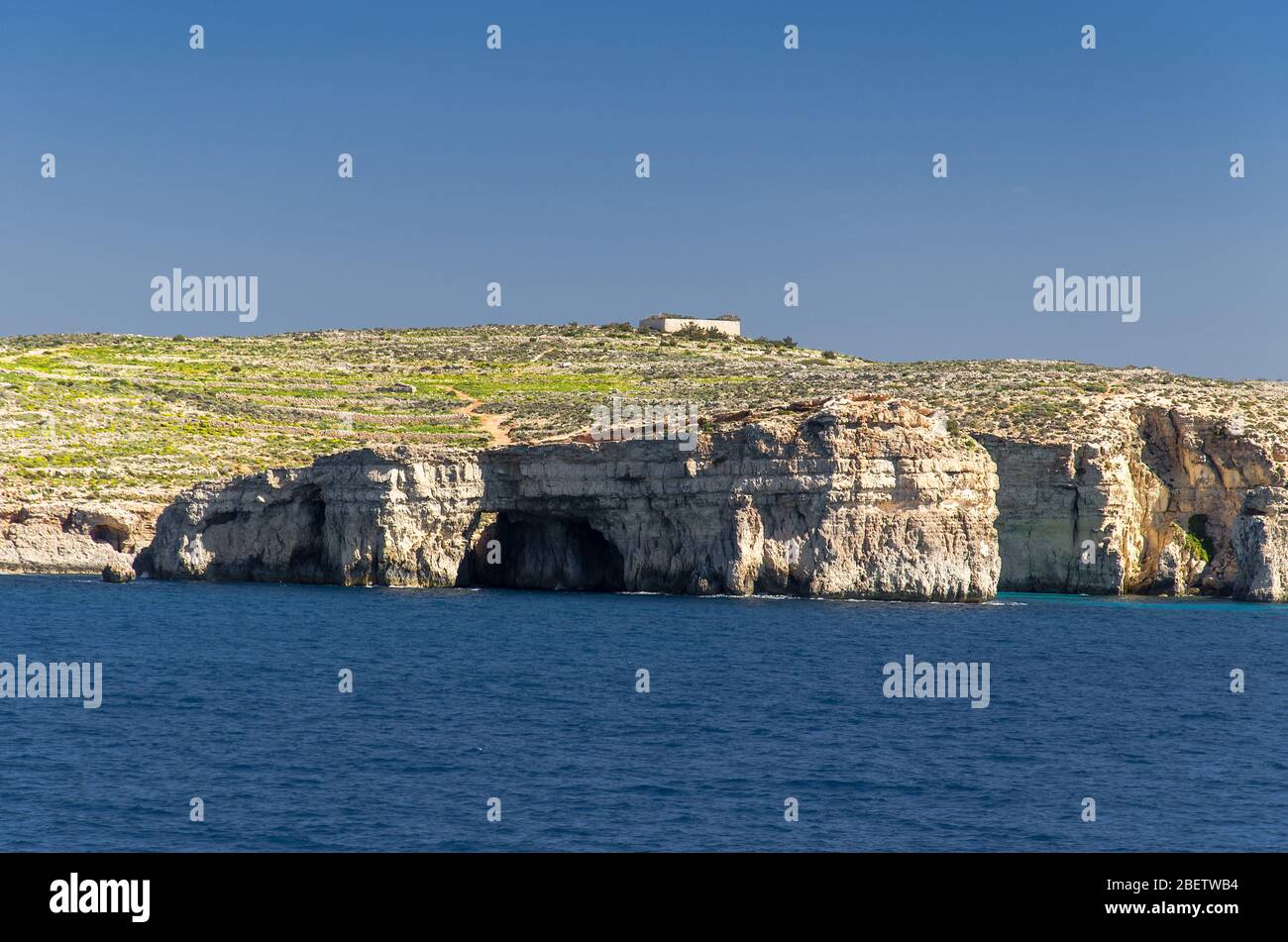 Scogliere e rocce dell'isola di Comino o Kemmuna dell'arcipelago maltese nel Mar Mediterraneo, Malta Foto Stock