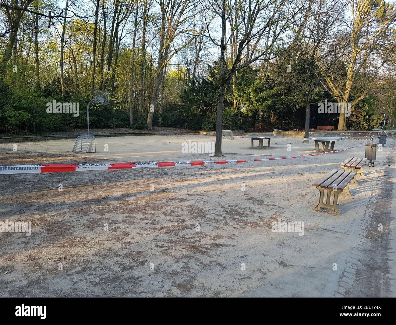 Vuoto, abbandonato parco atletico con campo da basket basket e ping pong ping-pong chiuso da nastro barriera di polizia a causa del covid-19 del virus corona Foto Stock