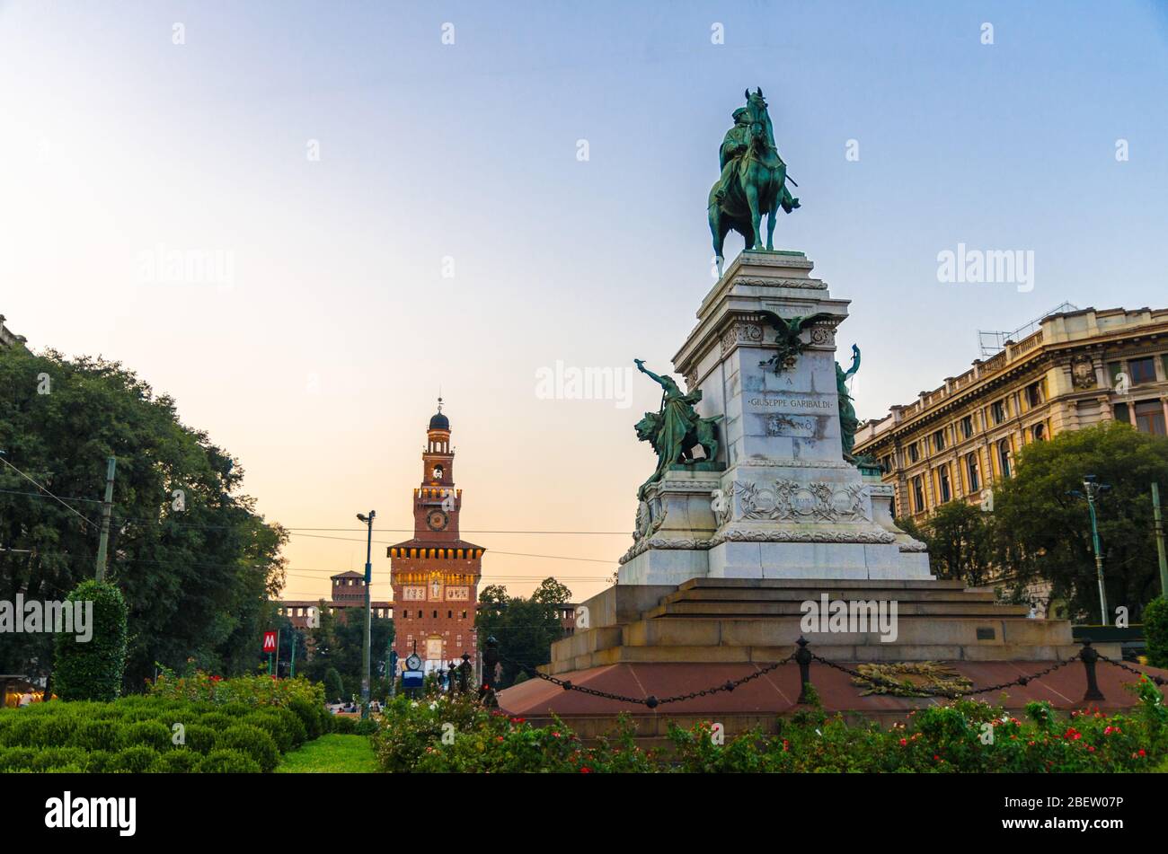 Monumento Giuseppe Garibaldi statua su Largo Cairoli di fronte al vecchio castello medievale Sforza Castello Sforzesco, torre la torre del Filarete con luci Foto Stock