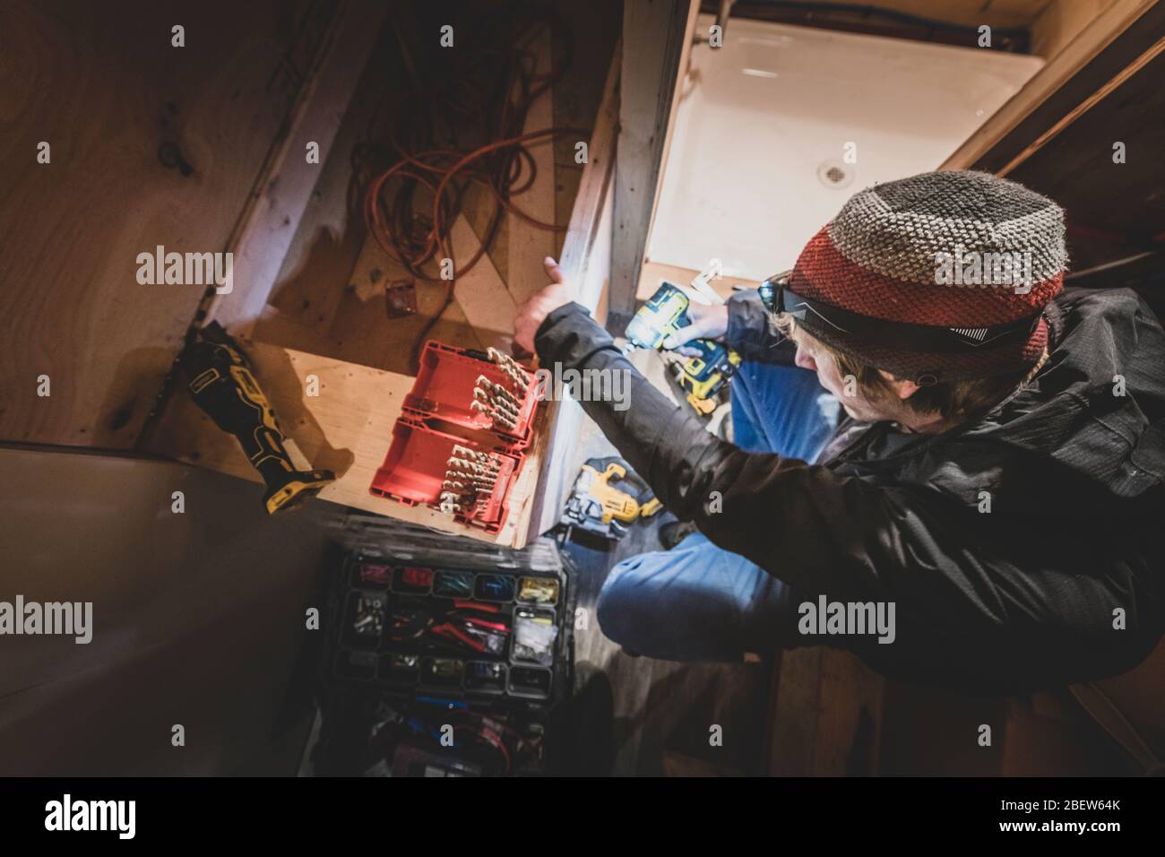 Vista dall'alto della perforazione manuale nel legno durante la conversione di un bus Foto Stock