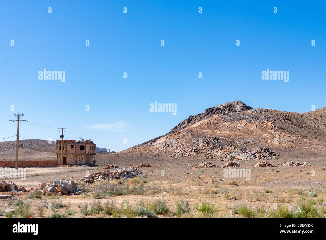 Paesaggio rurale roccioso con parzialmente costruito casa e colline in Marocco Foto Stock