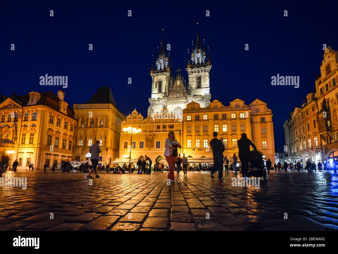 I turisti visitano la piazza della città vecchia di notte sotto le torri illuminate di nostra Signora prima della chiesa di Tyn a Praga, Repubblica Ceca. Foto Stock