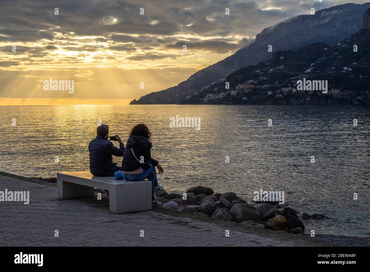 Una coppia che gode di un tramonto panoramico sul lungomare di Maiori sulla Costiera Amalfitana, Campania, Italia Foto Stock