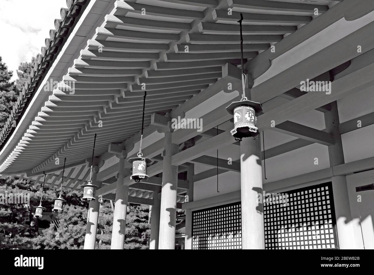 Una fila di lanterne da esterno appese sotto un tetto tradizionale nel Santuario Heian a Kyoto, in Giappone. Foto Stock