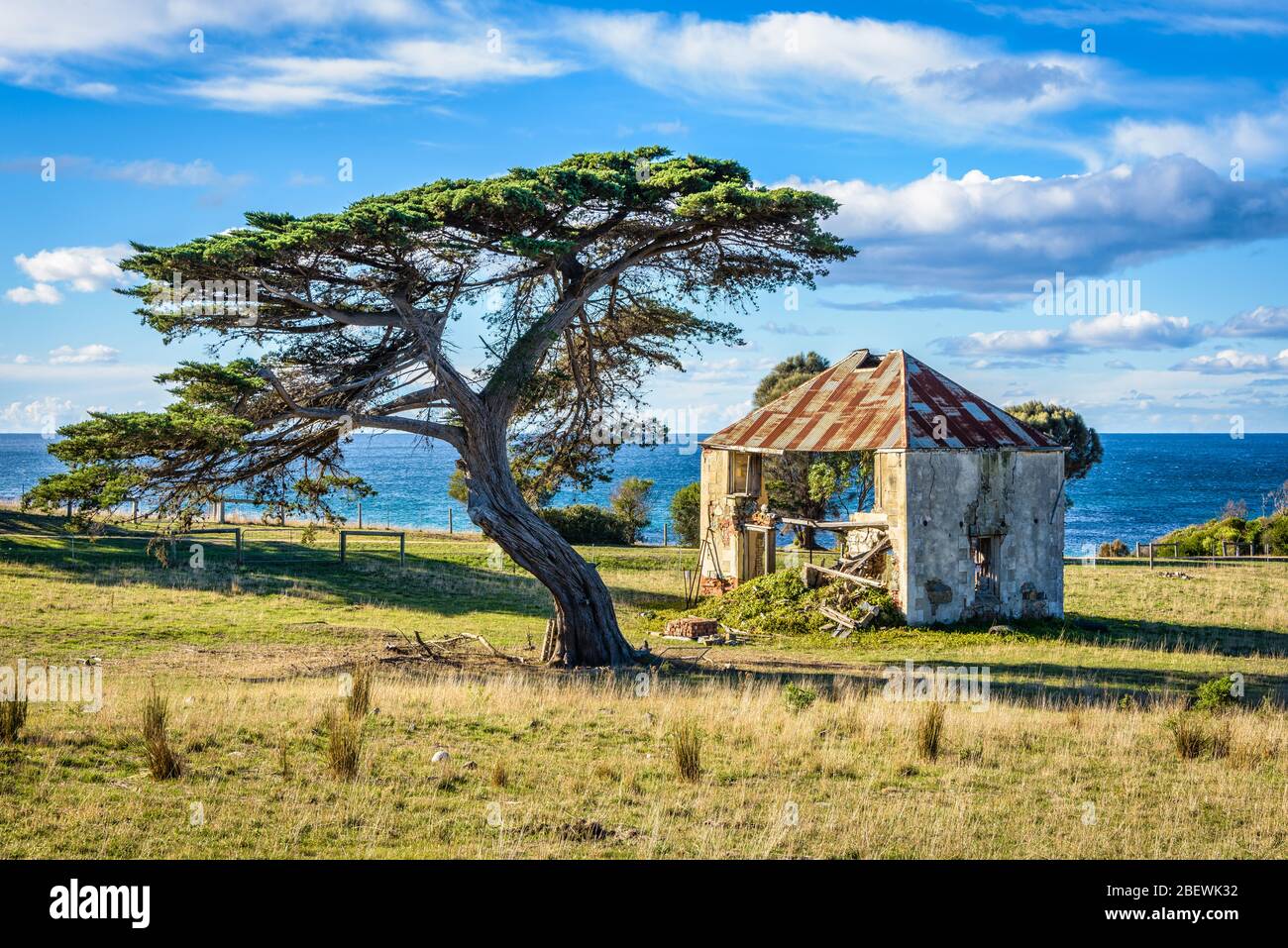 Un antico casale in pietra abbandonato e pioniere situato su una collina a Shelly Point lungo la costa orientale della Tasmania. Foto Stock