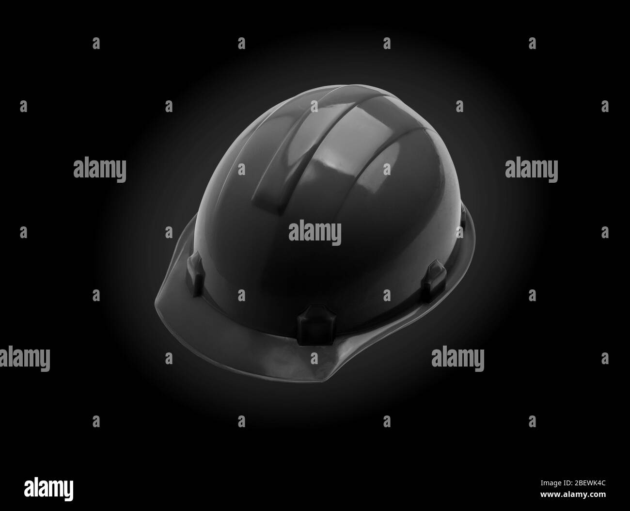 Casco di sicurezza nero su sfondo nero. Casco da costruzione per progetto di sicurezza di un lavoratore come ingegnere o lavoratore. Concetto di costruzione Foto Stock