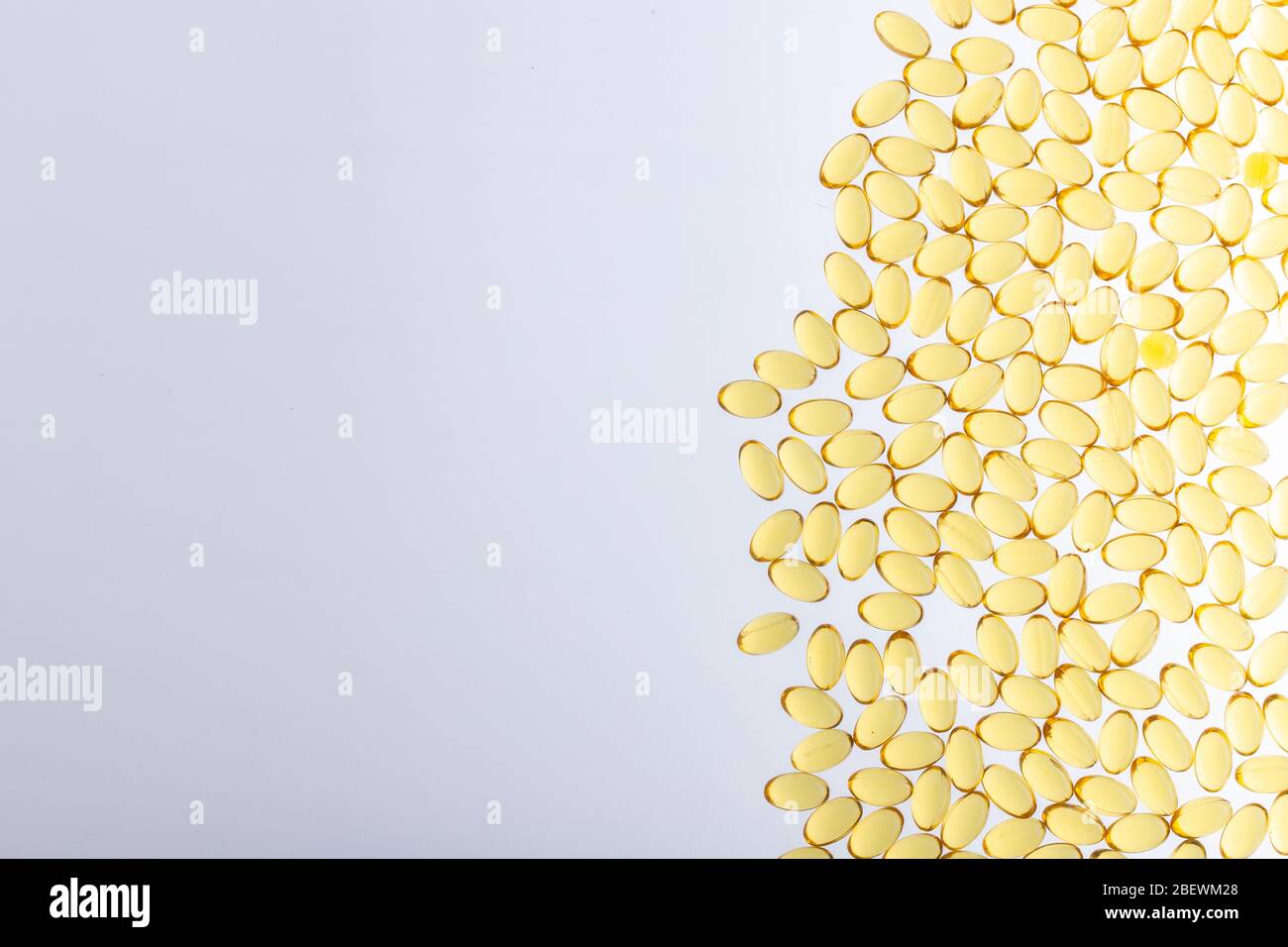 Softgels di Omega-3 su sfondo chiaro con spazio copia. Olio di pesce su sfondo bianco. Capsule gialle con medicinale. Medicamento medico di p Foto Stock