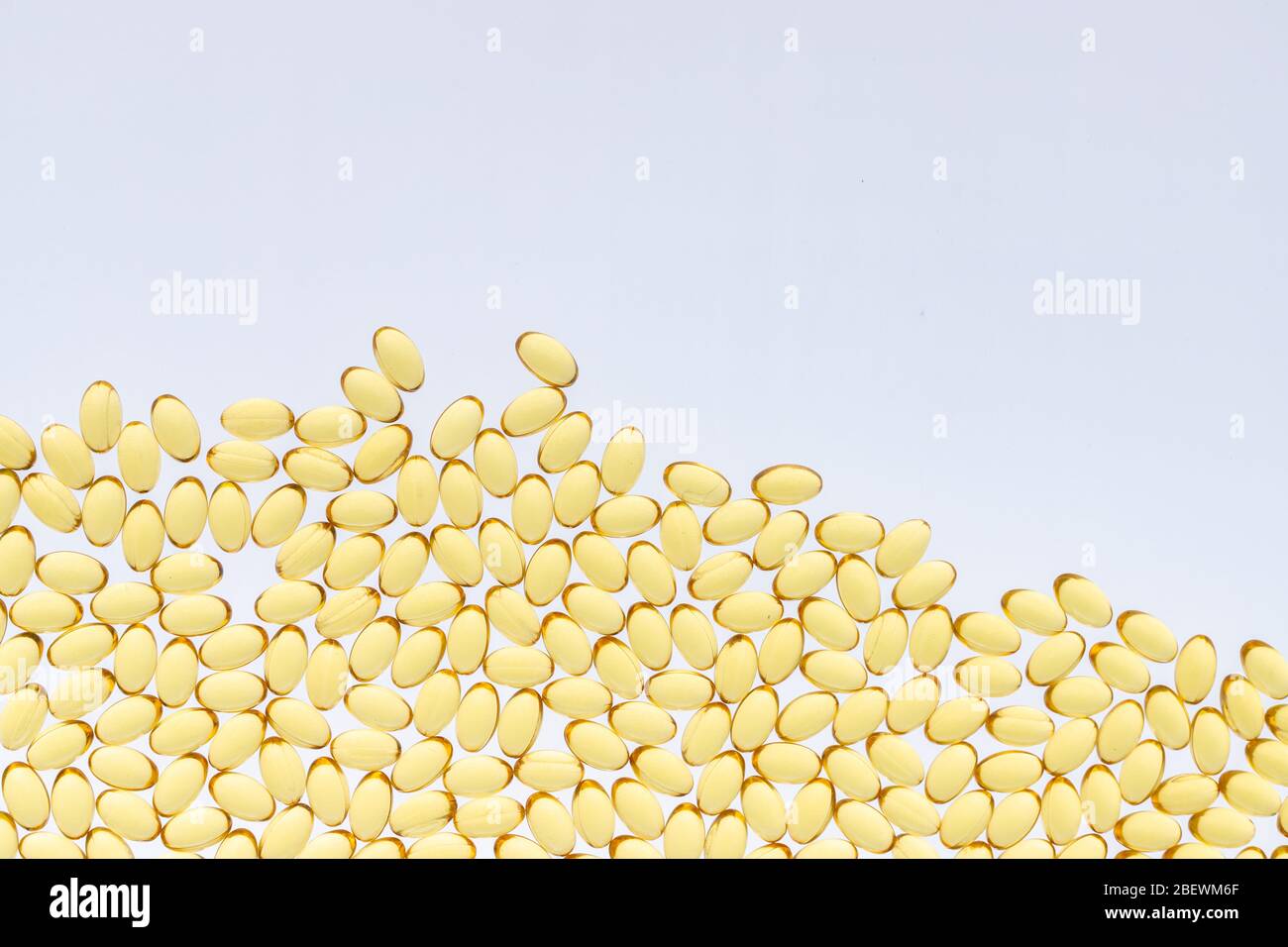 Divani di Omega-3 su sfondo isolato. Struttura delle capsule gialle su sfondo bianco isolato. Medicamento medico di acidi grassi polinsaturi Foto Stock