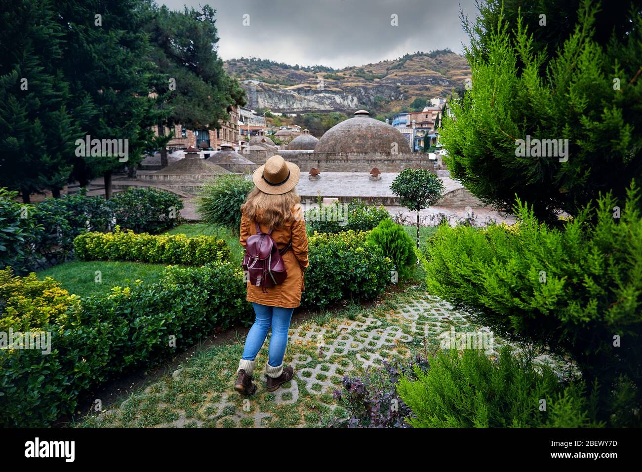 Bella donna in marrone cappello e giacca vicino al duomo di pubblico bagno solforico quartiere centrale di Tbilisi, Georgia Foto Stock