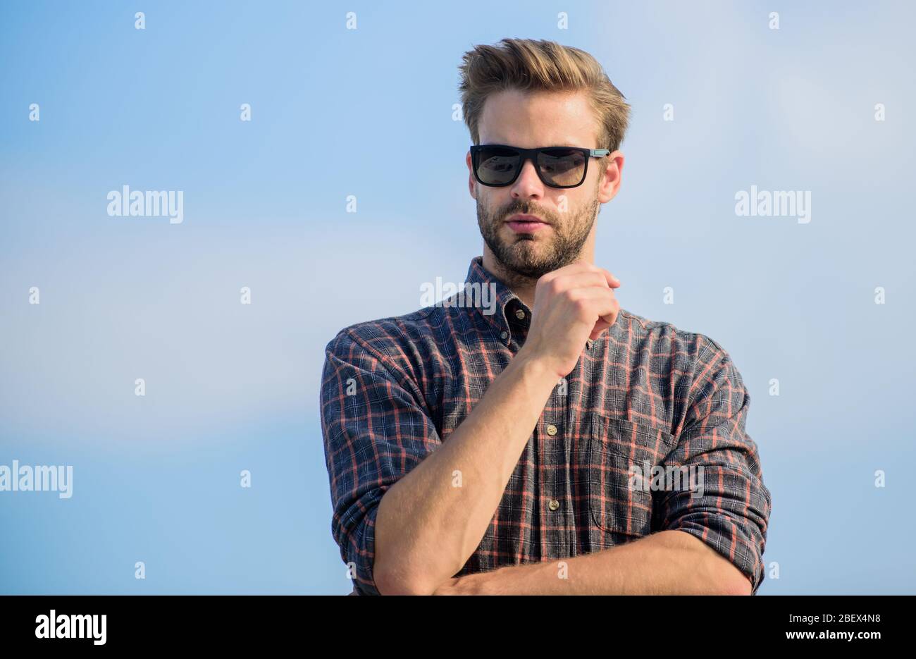 Concetto di protezione ultravioletta. Modello uomo occhiali esterni cielo blu sfondo. Visione perfetta. Vedere chiaro. Bel ragazzo indossare occhiali da sole. Hipster uomo in occhiali da sole alla moda. Occhiali da sole alla moda. Foto Stock