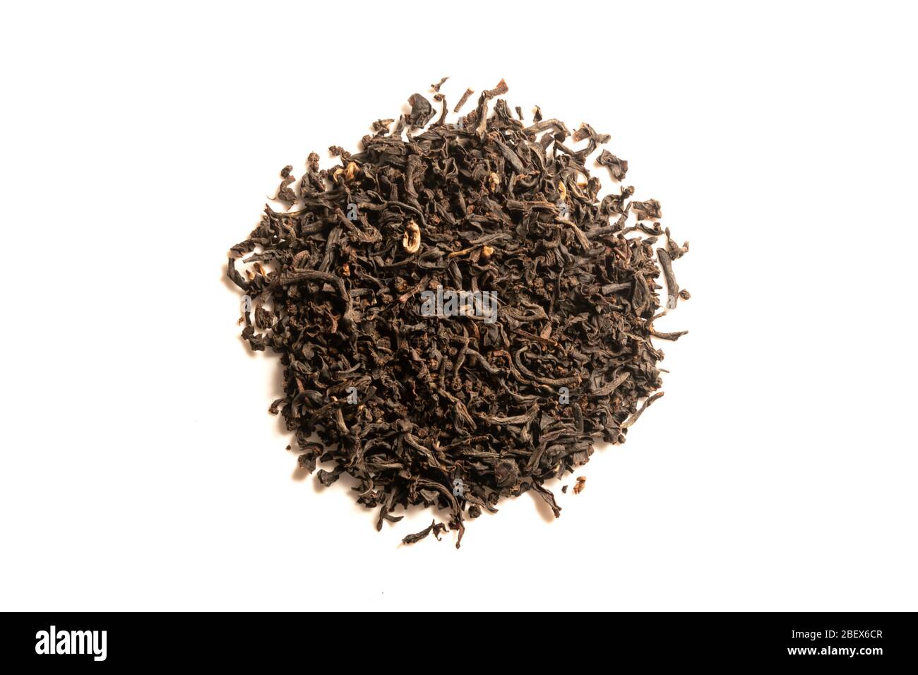 Mucchio di foglie di tè nero essiccato isolato su sfondo bianco. Preparare tè sfusi ogni giorno a foglie intere. Vista dall'alto. Foto Stock