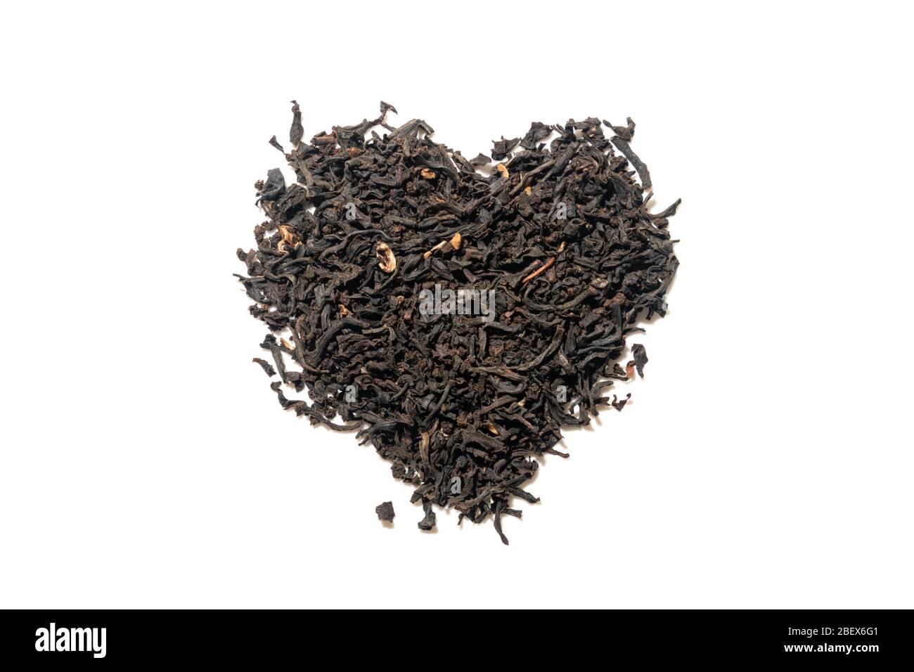 Mucchio di caffè di tutti i giorni sciolto biologico tè nero forma cuore fatto con foglie intere isolato su bianco. Vista dall'alto. Foto Stock