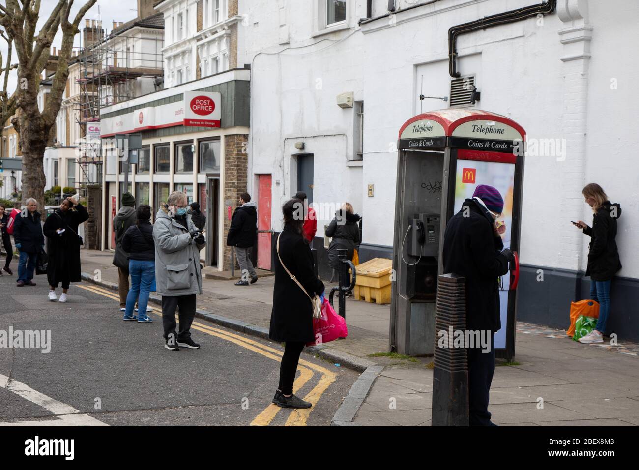 Kilburn, Londra, Regno Unito, 4 aprile 2020 UNA coda fuori da un ufficio postale mentre una politica per far rispettare le distanze sociali è in vigore durante il virus Covid-19. Foto Stock