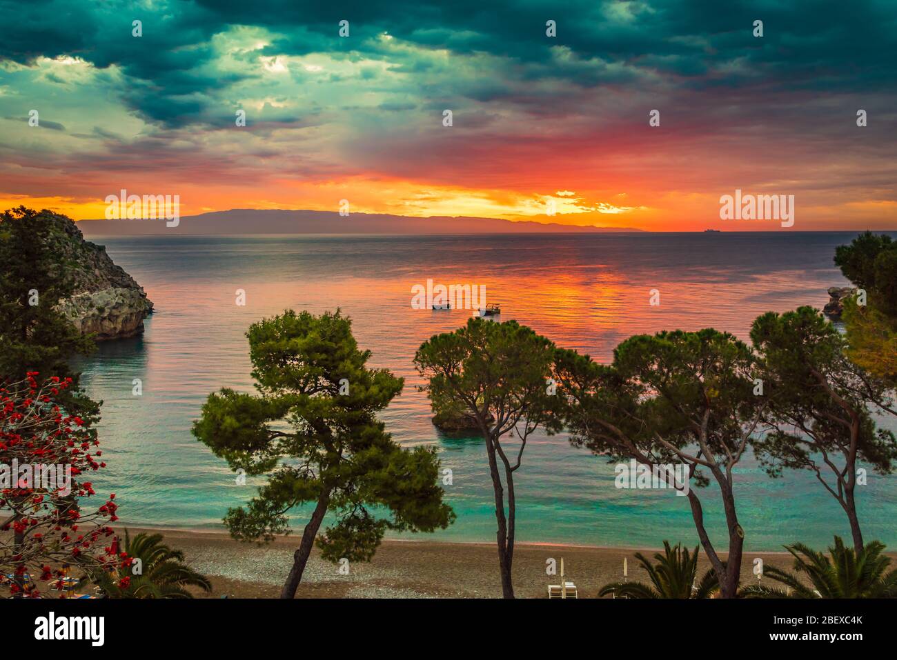 Vista mozzafiato dell'alba dalla spiaggia migliore di Taormina - Mazzaro, vicino alla Riserva Naturale Isolabella, Sicilia Foto Stock