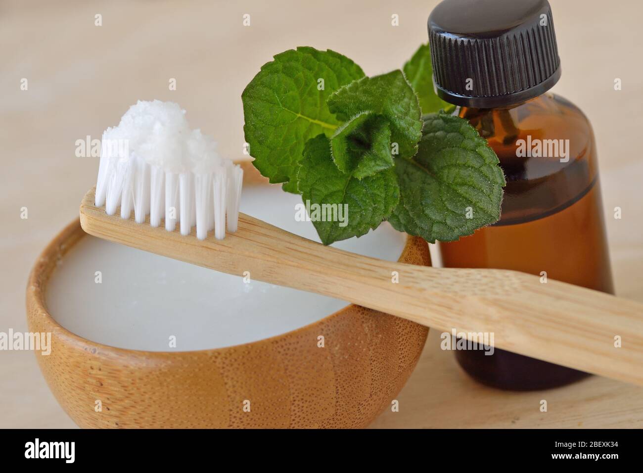 Olio di cocco in una ciotola con uno spazzolino da denti in legno e olio  essenziale di menta piperita - dentifricio naturale fatto in casa Foto  stock - Alamy