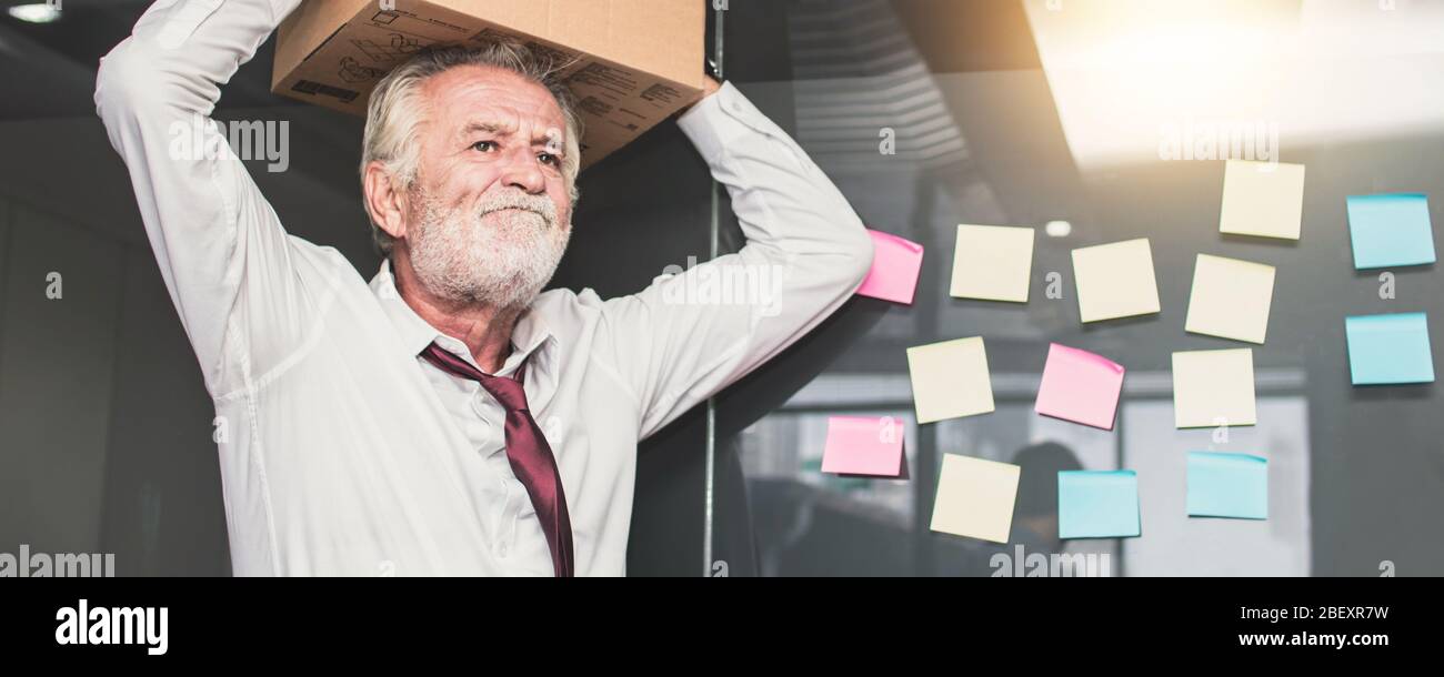 pensionamento e disposizione fuori concetto, vecchio uomo d'affari che prepara la scatola e che tiene gli oggetti fuori dell'ufficio. Frustrazione e perdita di lavoro Foto Stock