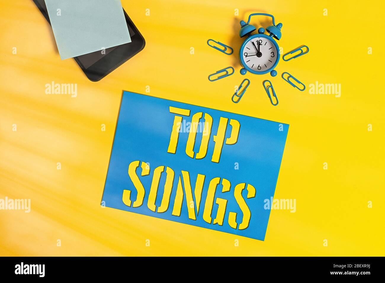 Scrittura di testo Top Songs. Canzone di foto concettuale registrata che diventa ampiamente popolare o ben noto smartphone metallo sveglia clip foglio di carta NO Foto Stock