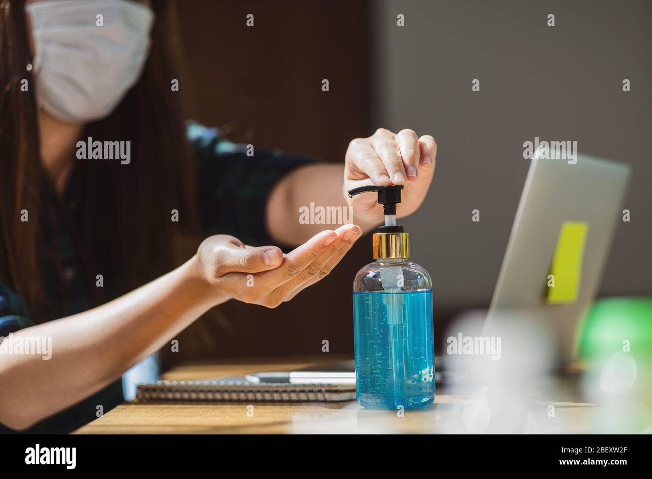 Closeup femminile asiatica utilizzando igienizzante mani pompando gel di alcol e lavando prima di lavorare con il laptop in casa, coronavirus o covid1 Foto Stock Closeup femminile asiatica utilizzando igienizzante mani pompando gel di alcol e lavando prima di lavorare con il laptop in casa, coronavirus o covid1 Foto Stock
